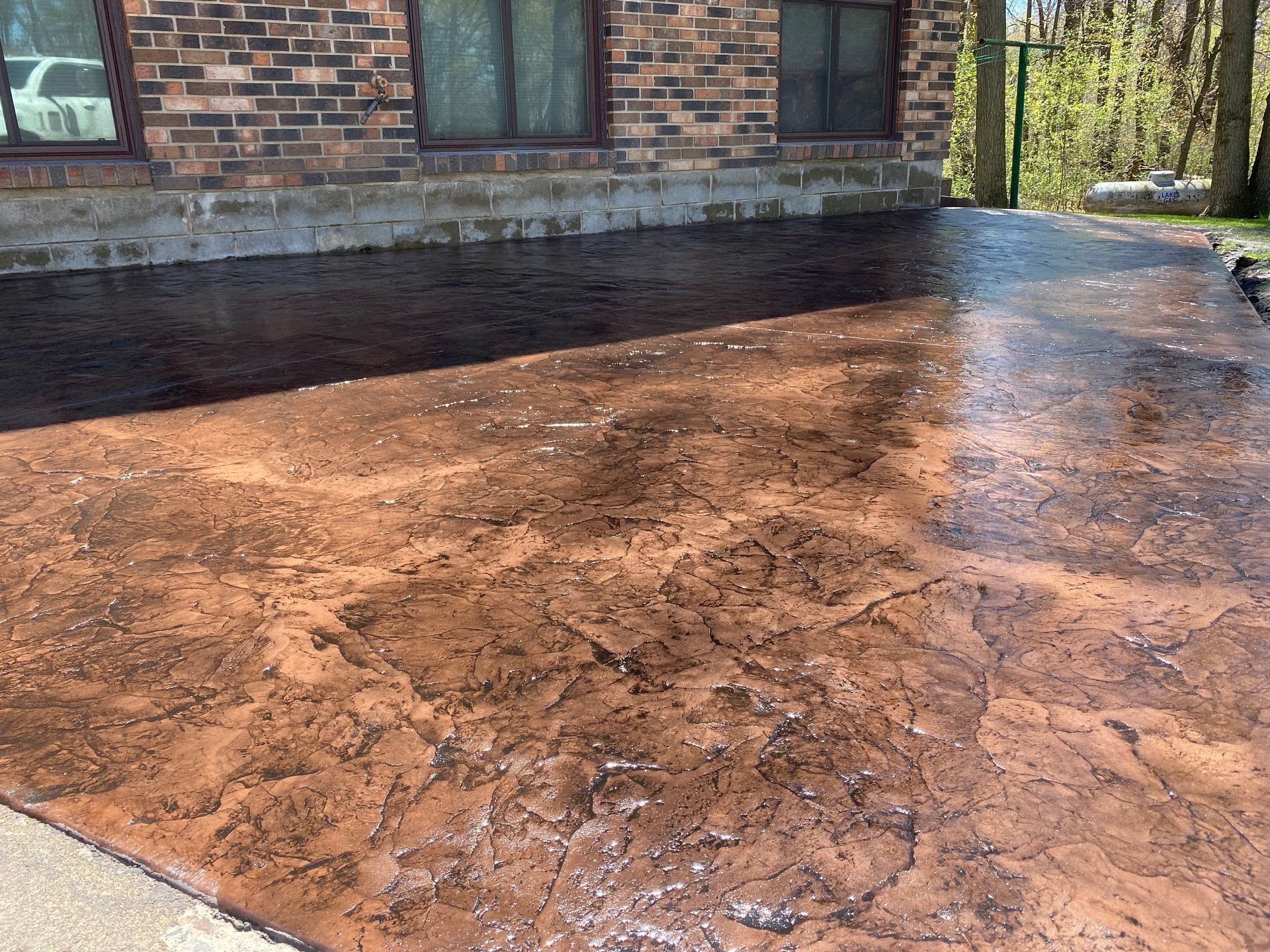 A brick house with a concrete driveway in front of it.