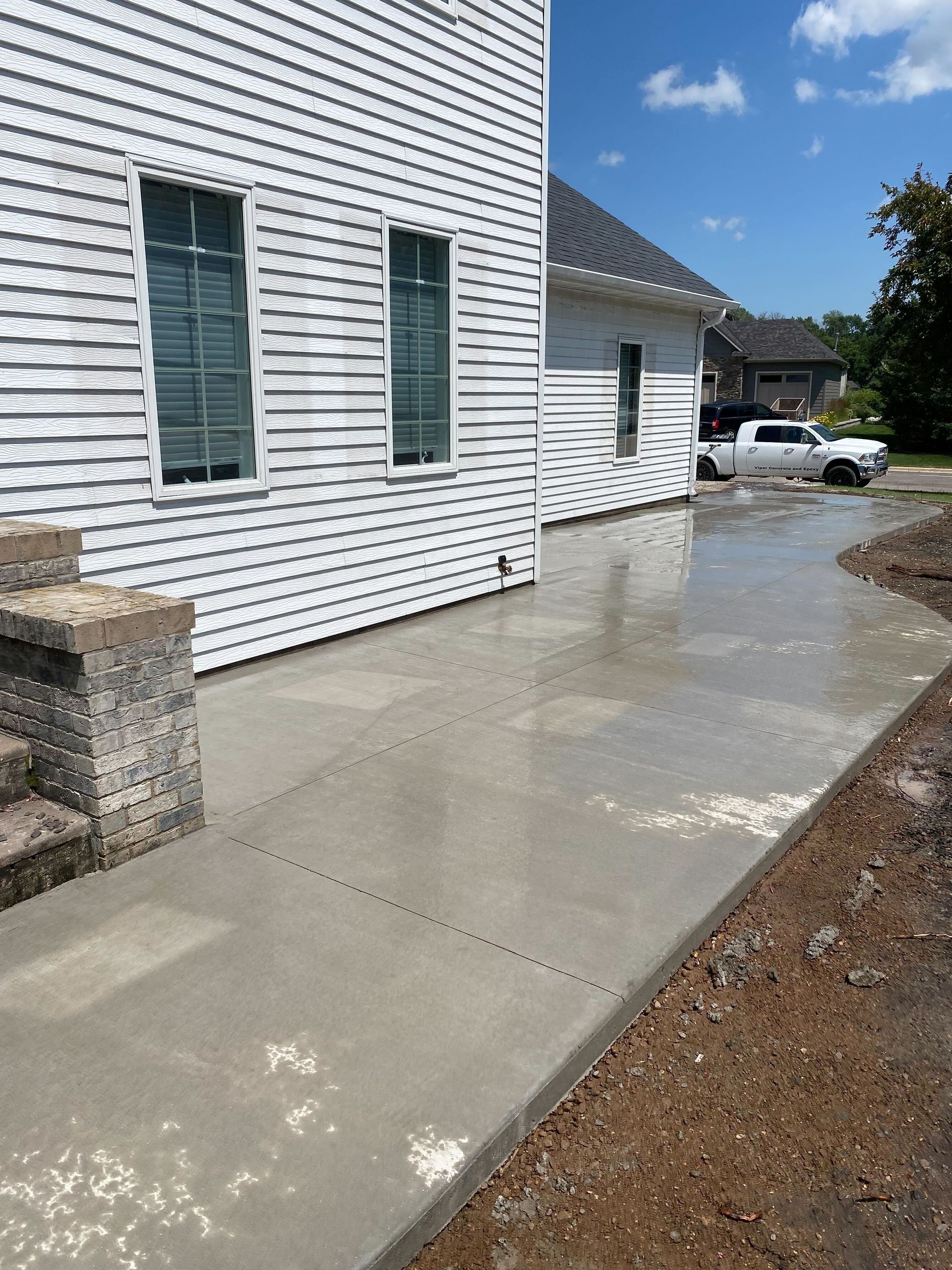A white house with a concrete walkway in front of it