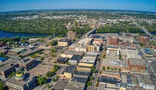 An aerial view of a city with a river in the background.