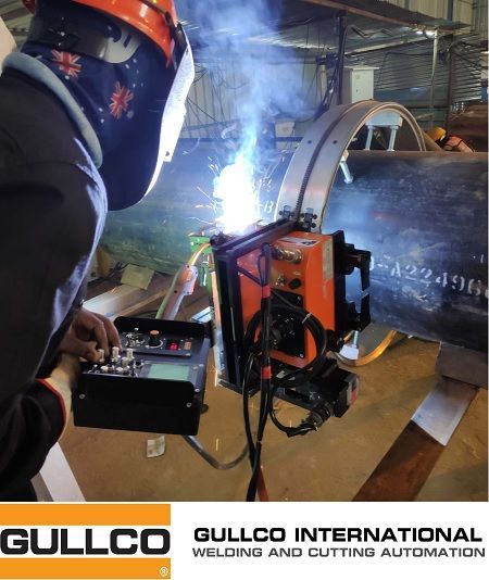 A man is welding a pipe with gullco international welding and cutting automation in the background