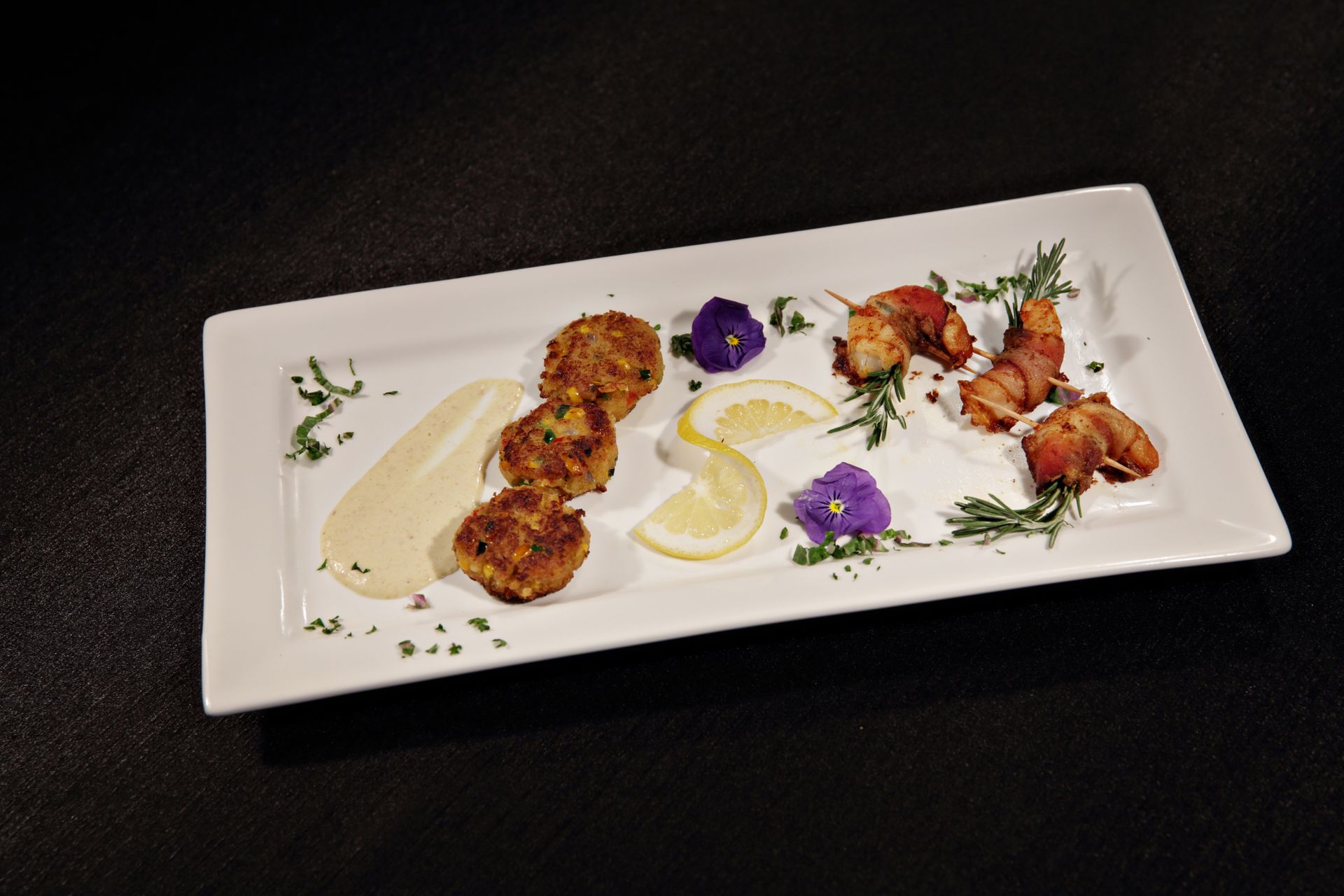 A white plate topped with shrimp and lemon slices