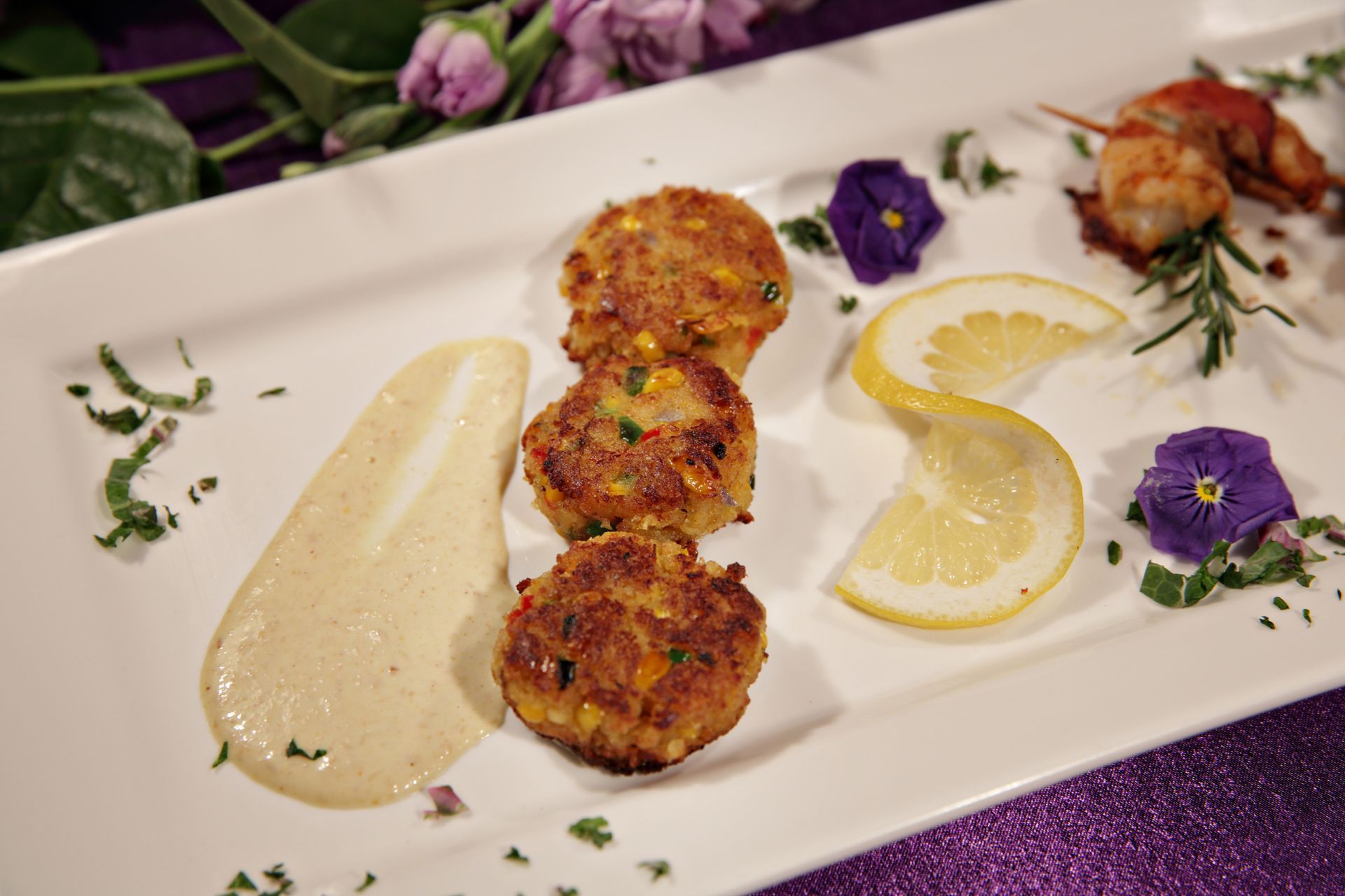 A white plate topped with crab cakes and lemon slices