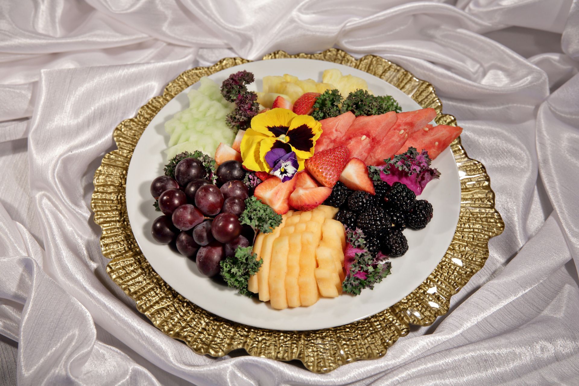 A white plate topped with a variety of fruits and vegetables.