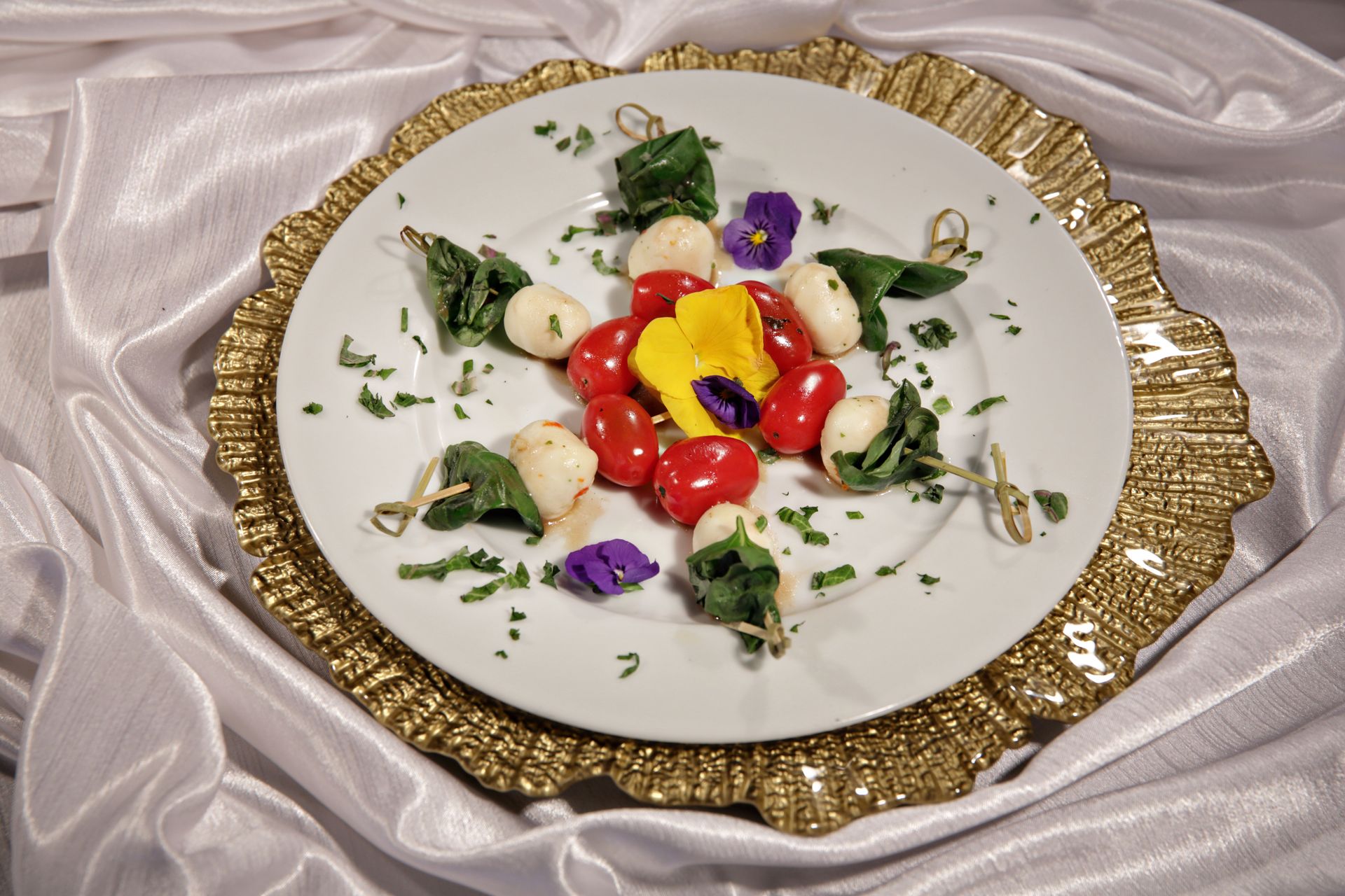 A white plate with tomatoes and mozzarella on it