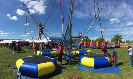 A group of people are playing on a trampoline in a field.
