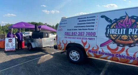 A white van with flames on it is parked in a parking lot.