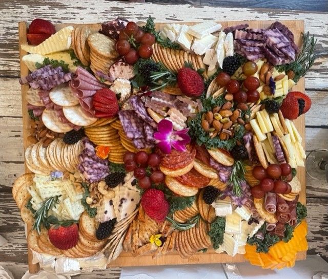 A wooden cutting board filled with lots of different types of food.