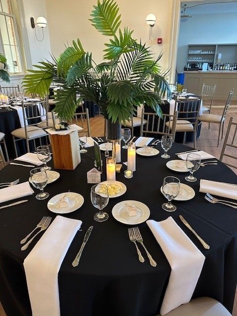 A table with a black table cloth and white napkins