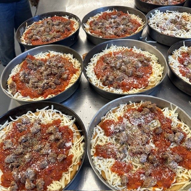 Several bowls of spaghetti and meatballs are on a table