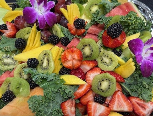 A plate of fruit with flowers on top of it