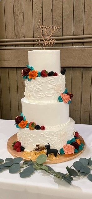 A wedding cake is sitting on top of a wooden table.
