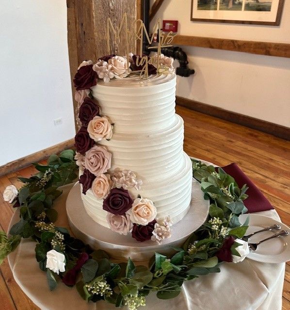 A wedding cake on a table with flowers and leaves