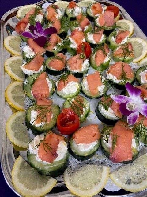 A tray of smoked salmon cucumber appetizers with lemon slices