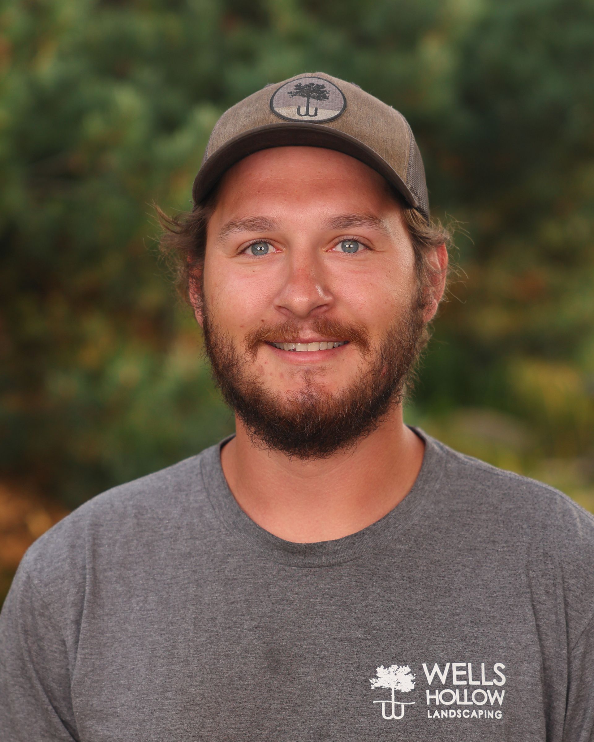 A man wearing a wells hollow shirt and hat