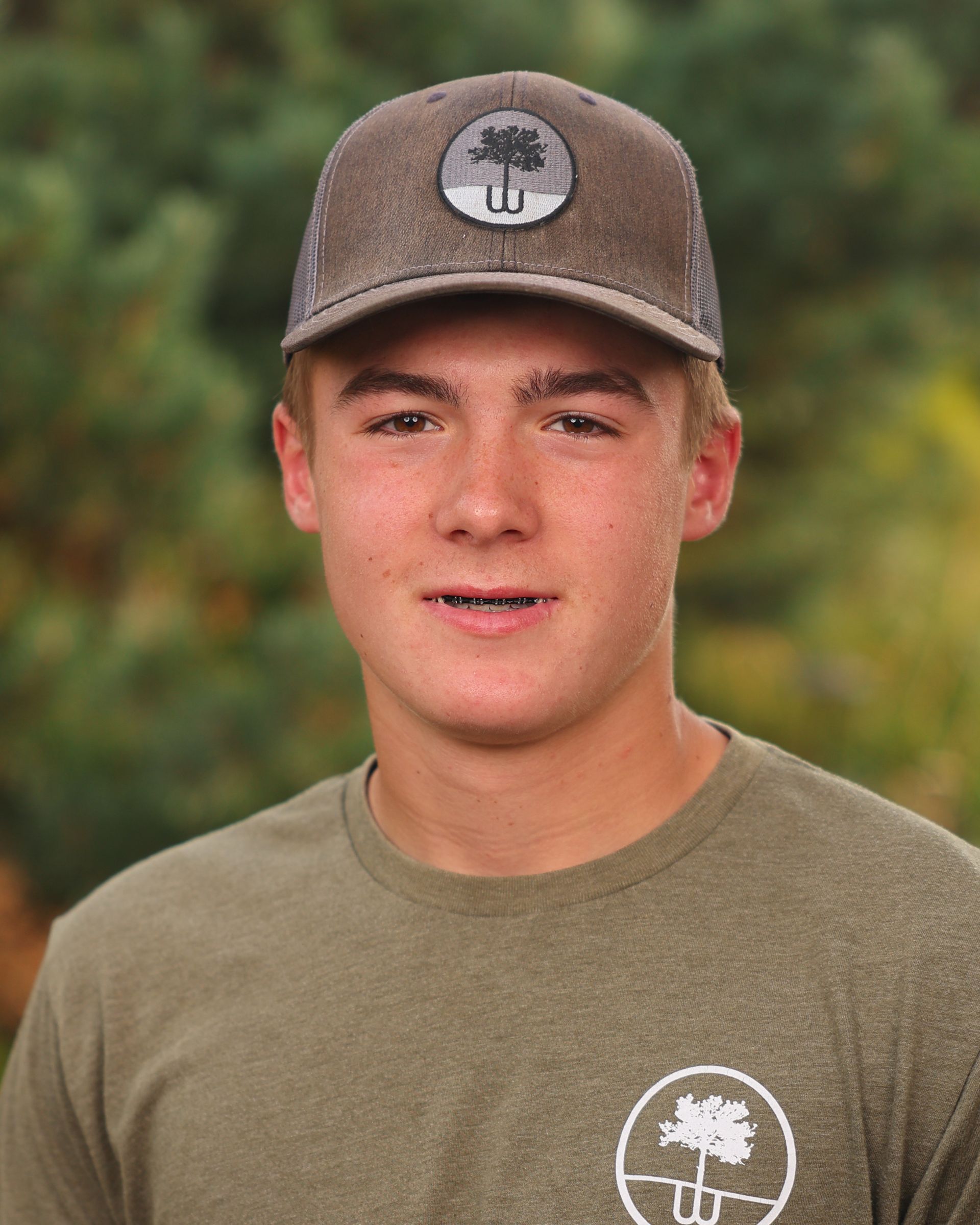 A young man wearing a hat and a green shirt