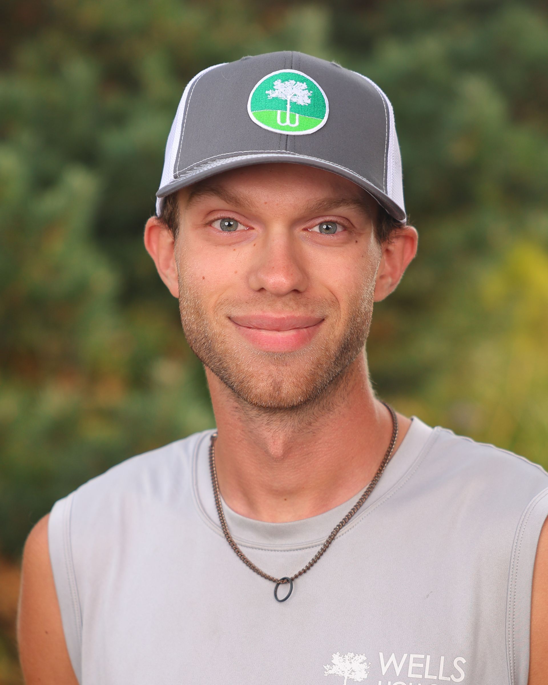 A man wearing a hat and a shirt that says wells