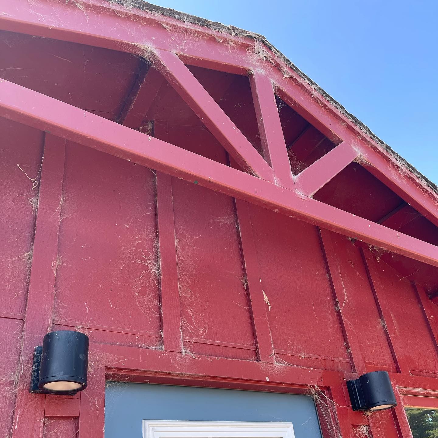 A red building with a white door and a blue sky in the background