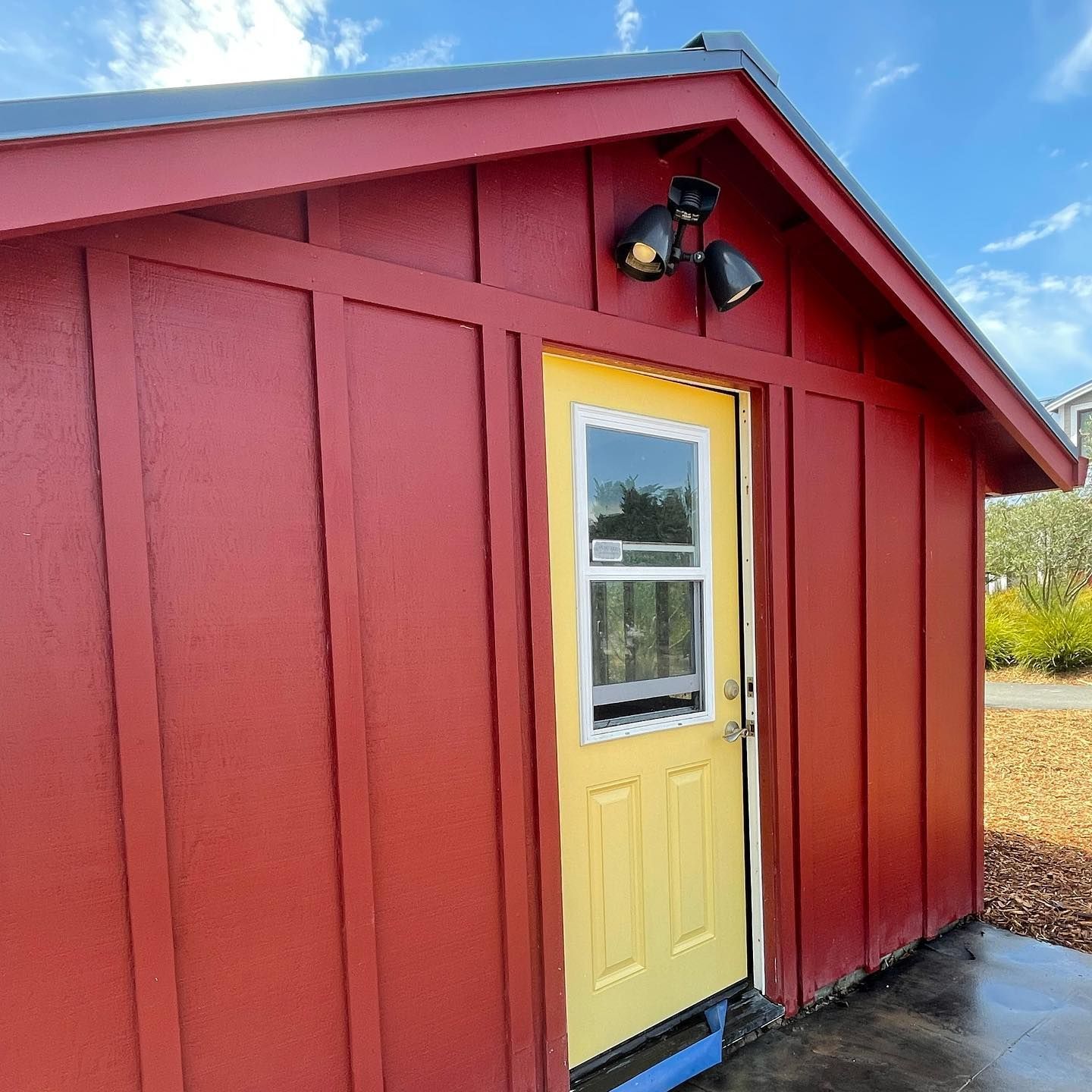 A red shed with a yellow door and window