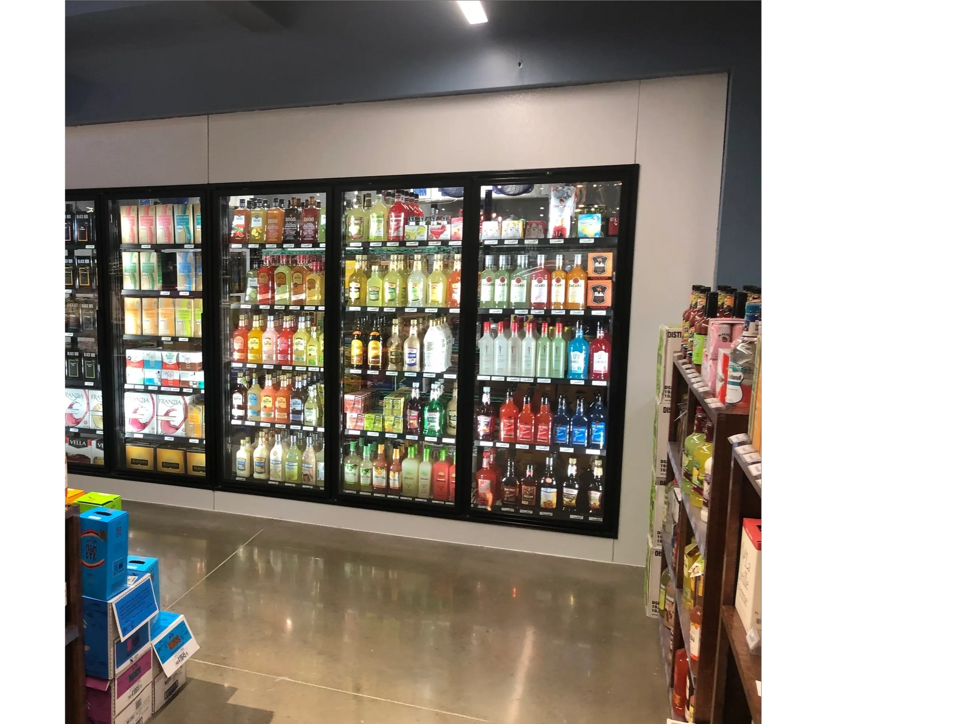 Beverage coolers stocked with various drinks in a store.