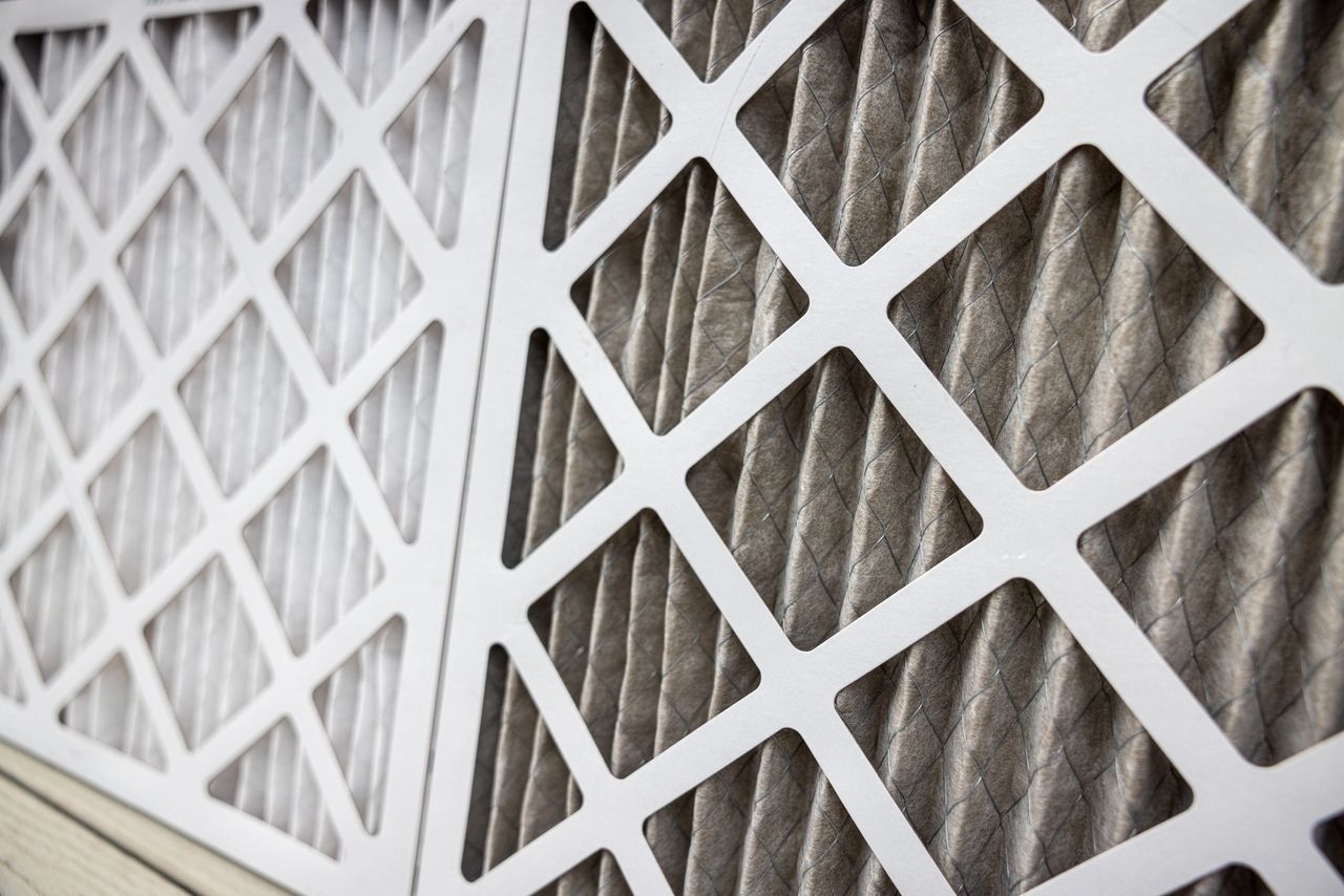 Two HVAC air filters; one clean, one dirty, showing the contrast of use.