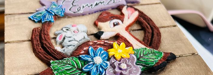 Wooden Bambi art piece with flowers and a bunny, the name Emma on top.