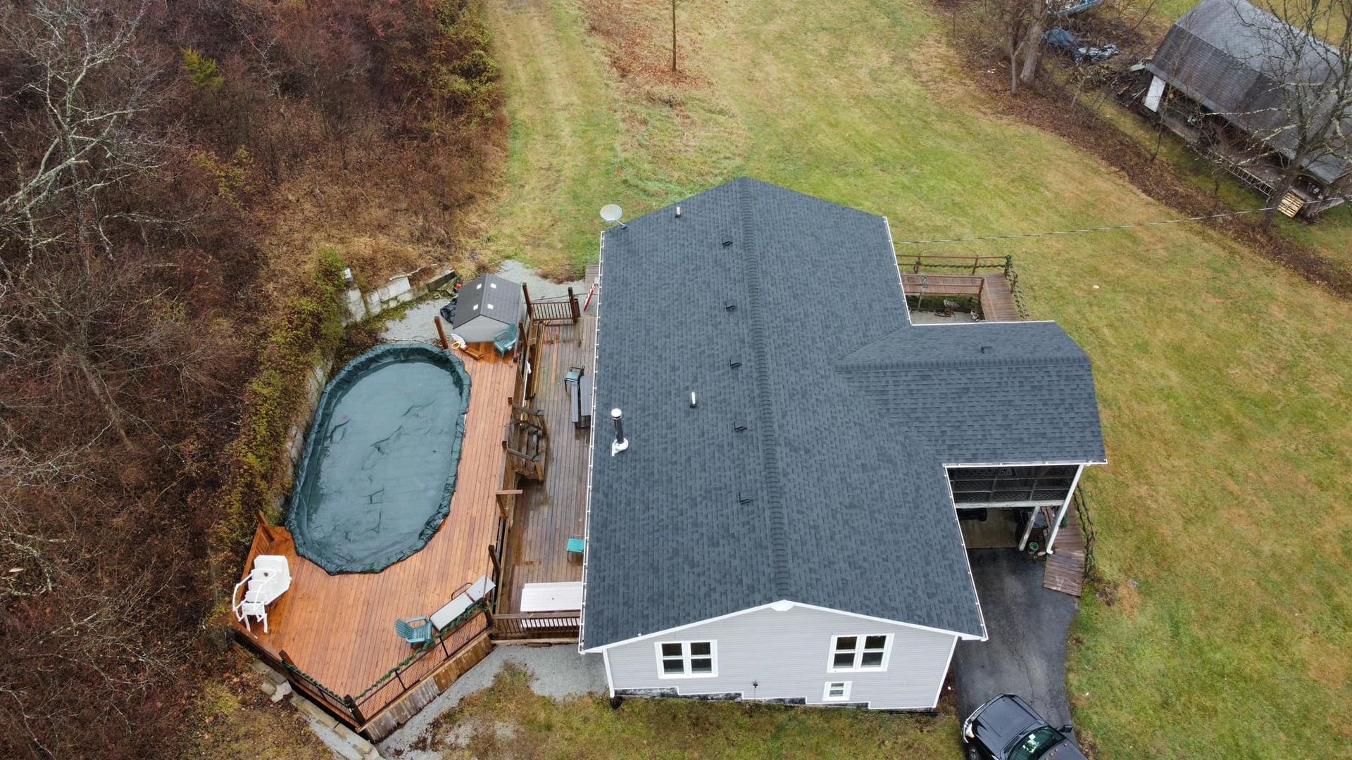 An aerial view of a house with a pool and a car parked in front of it.