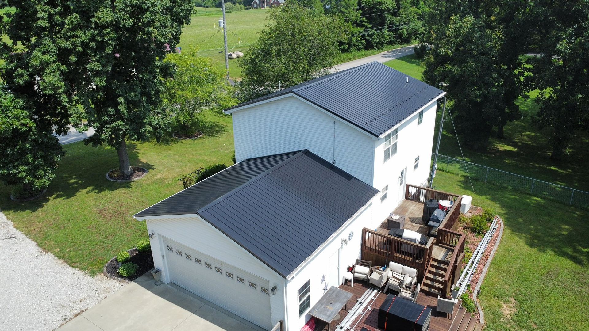 An aerial view of a white house with a black roof.