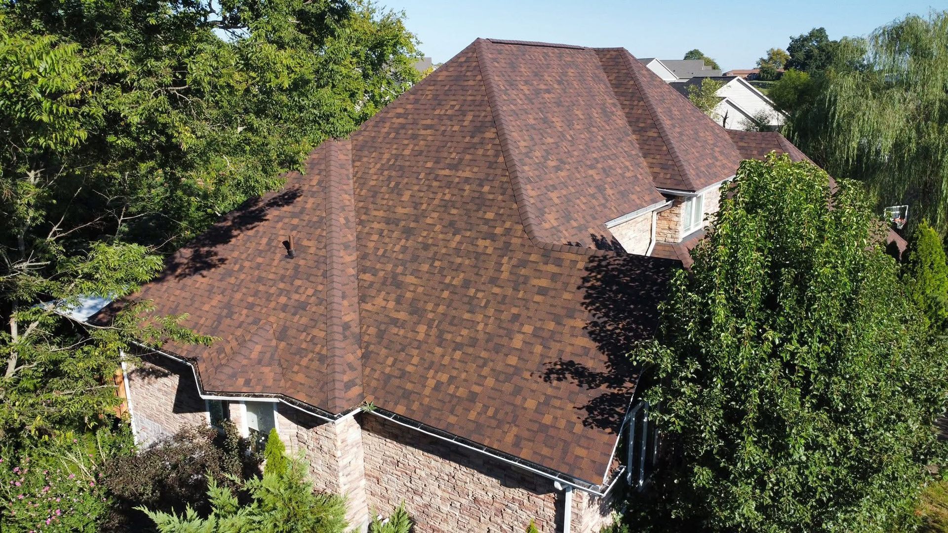 An aerial view of a house with a pool and a car parked in front of it.
