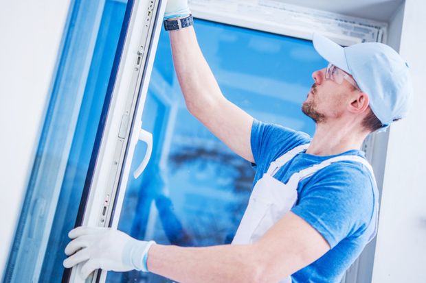 man installing window glass