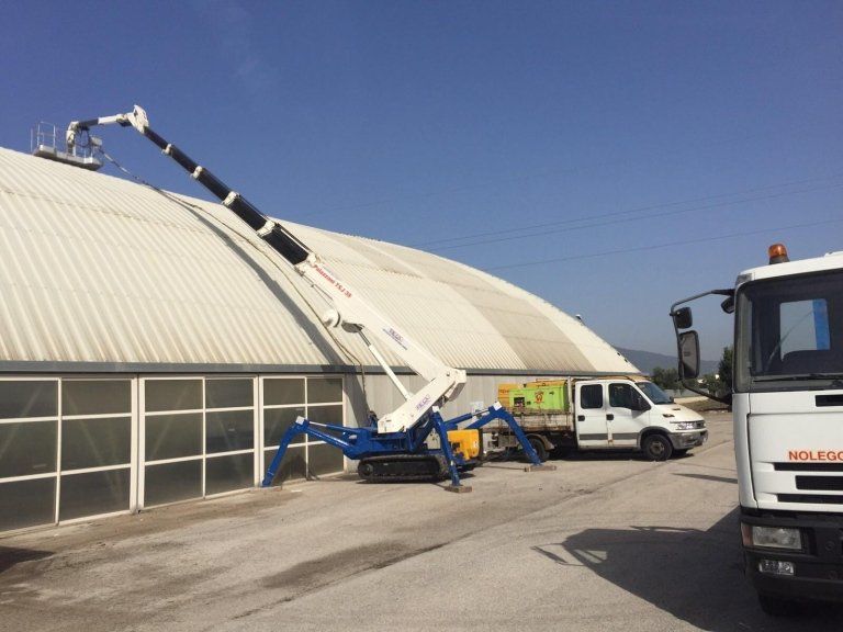 un braccio meccanico con una piattaforma su un tetto di uno stabile