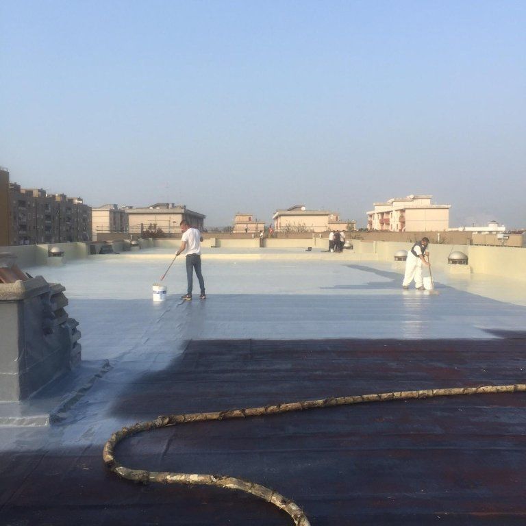 degli uomini al lavoro su un ampio tetto