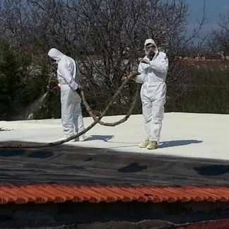 un uomo con una tuta protettiva che spruzza dell’acqua nel rimorchio di un pick up