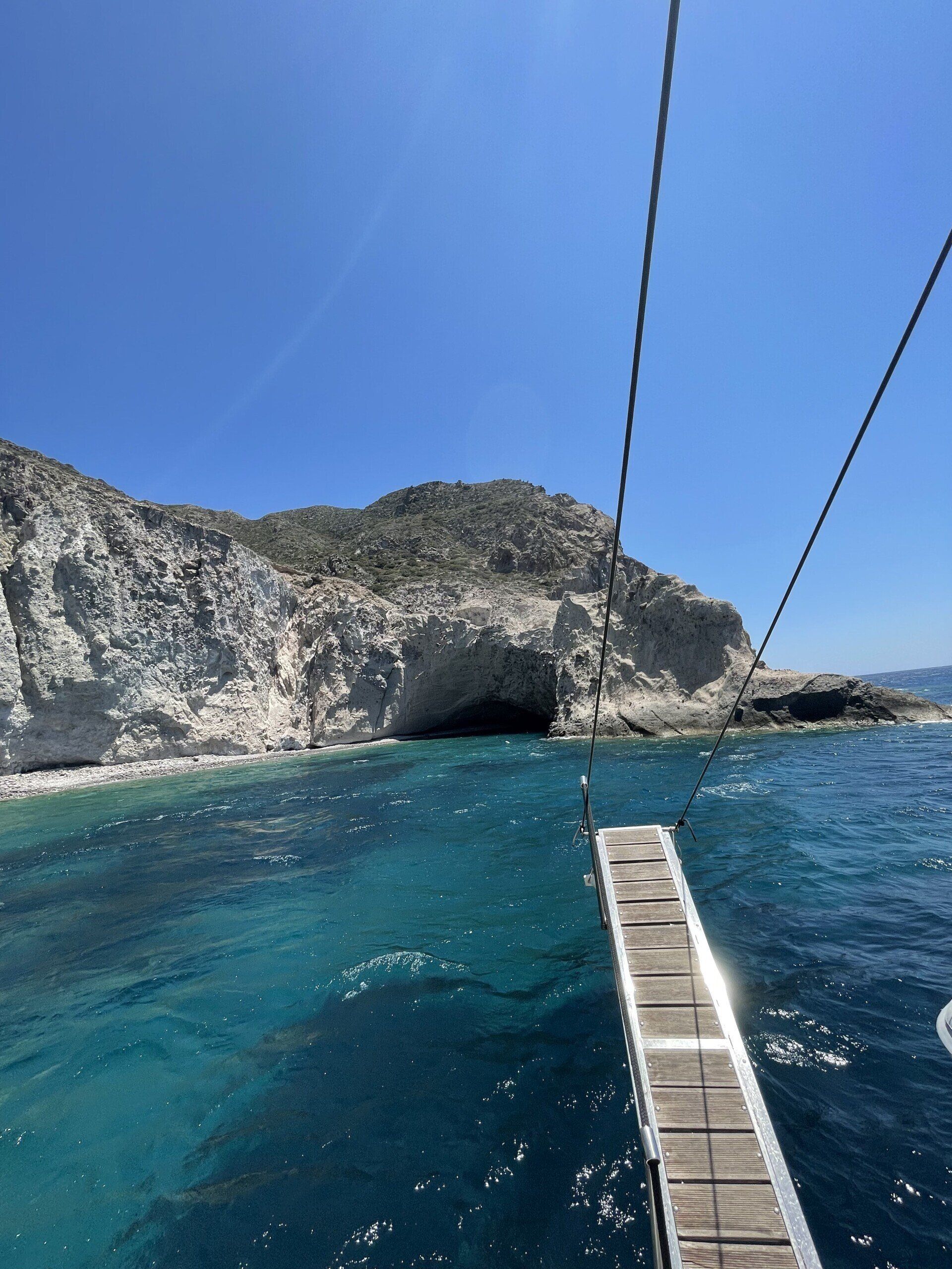 A dock in the middle of the ocean with a mountain in the background