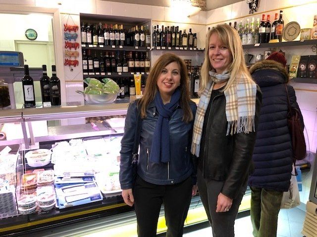 Two women are standing next to each other in a grocery store.