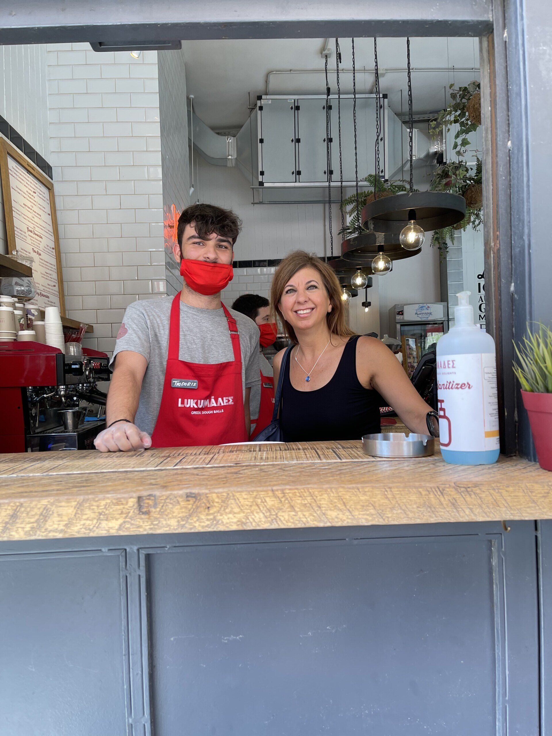 A man and a woman are standing behind a counter in a restaurant.