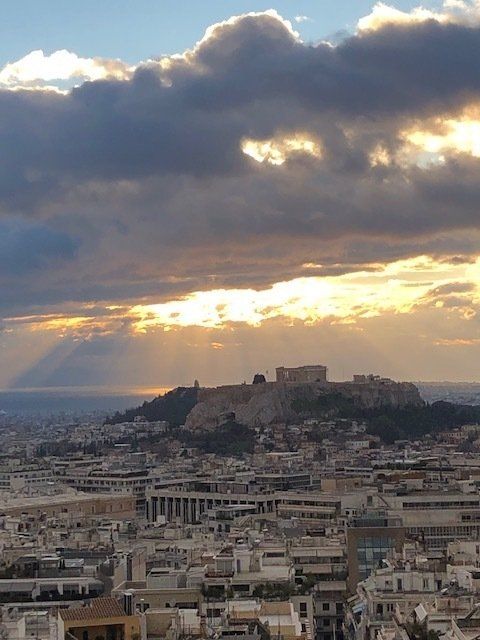 The sun is shining through the clouds over a city