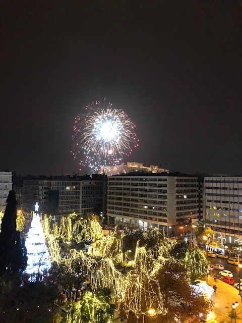 Fireworks are displayed over a city at night