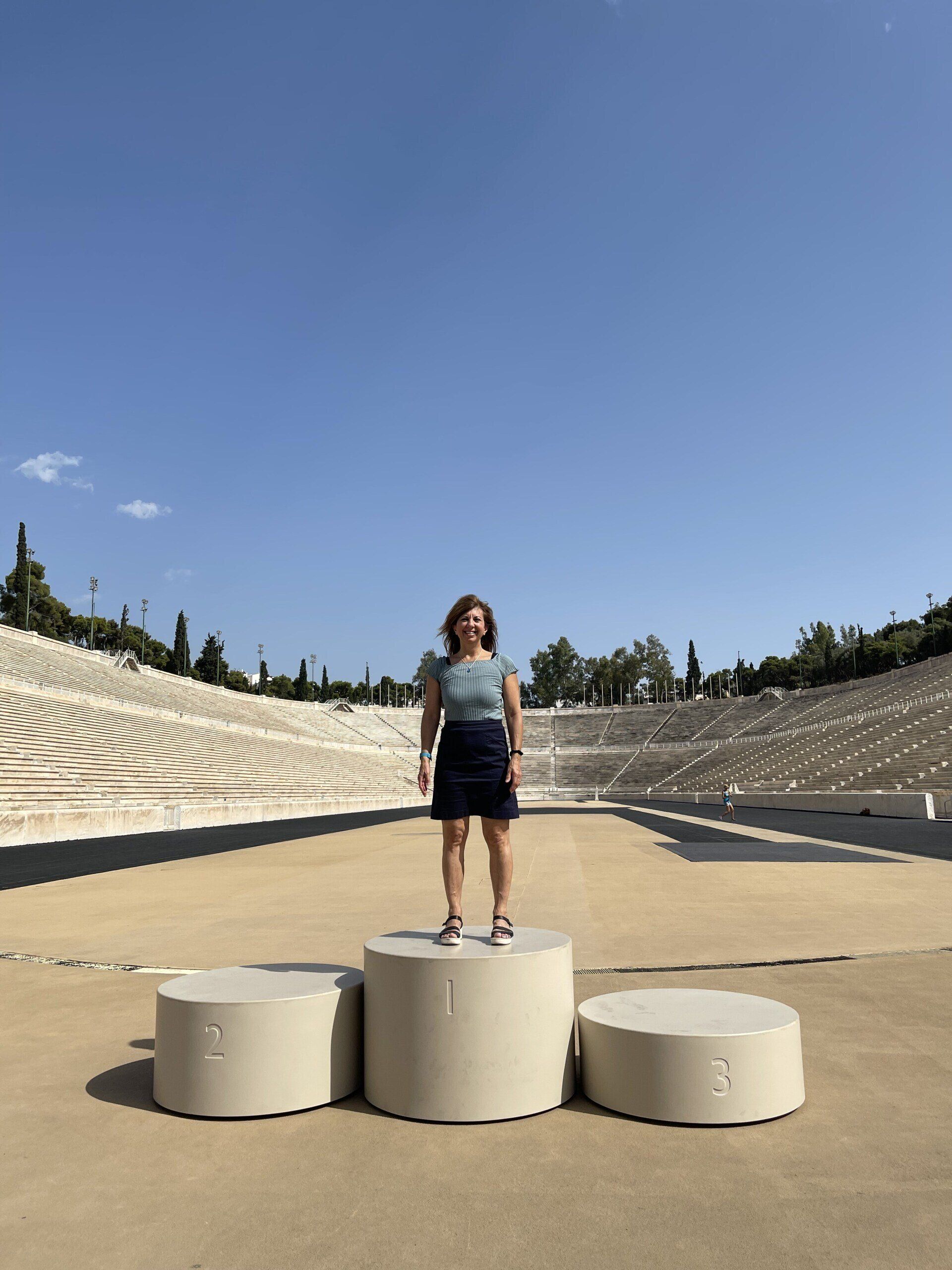 A woman is standing on a podium in front of an amphitheater.