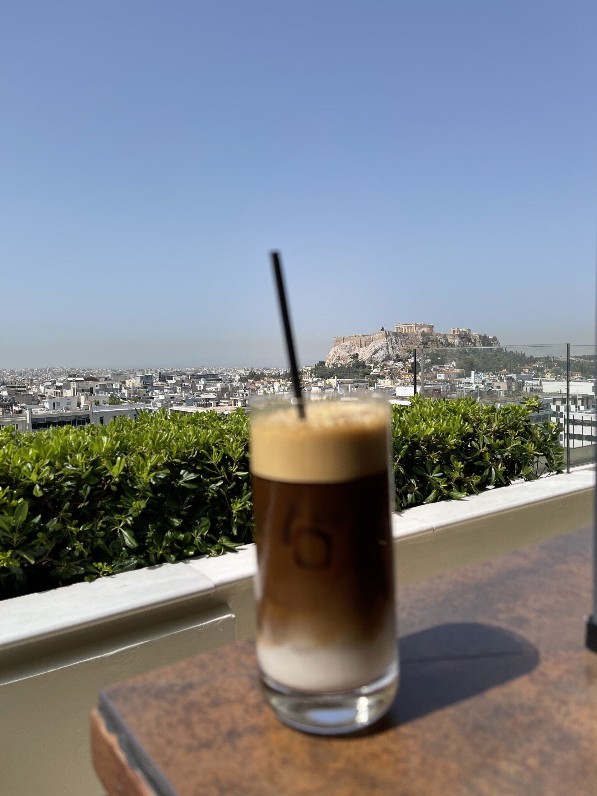 A glass of coffee with a straw on a table