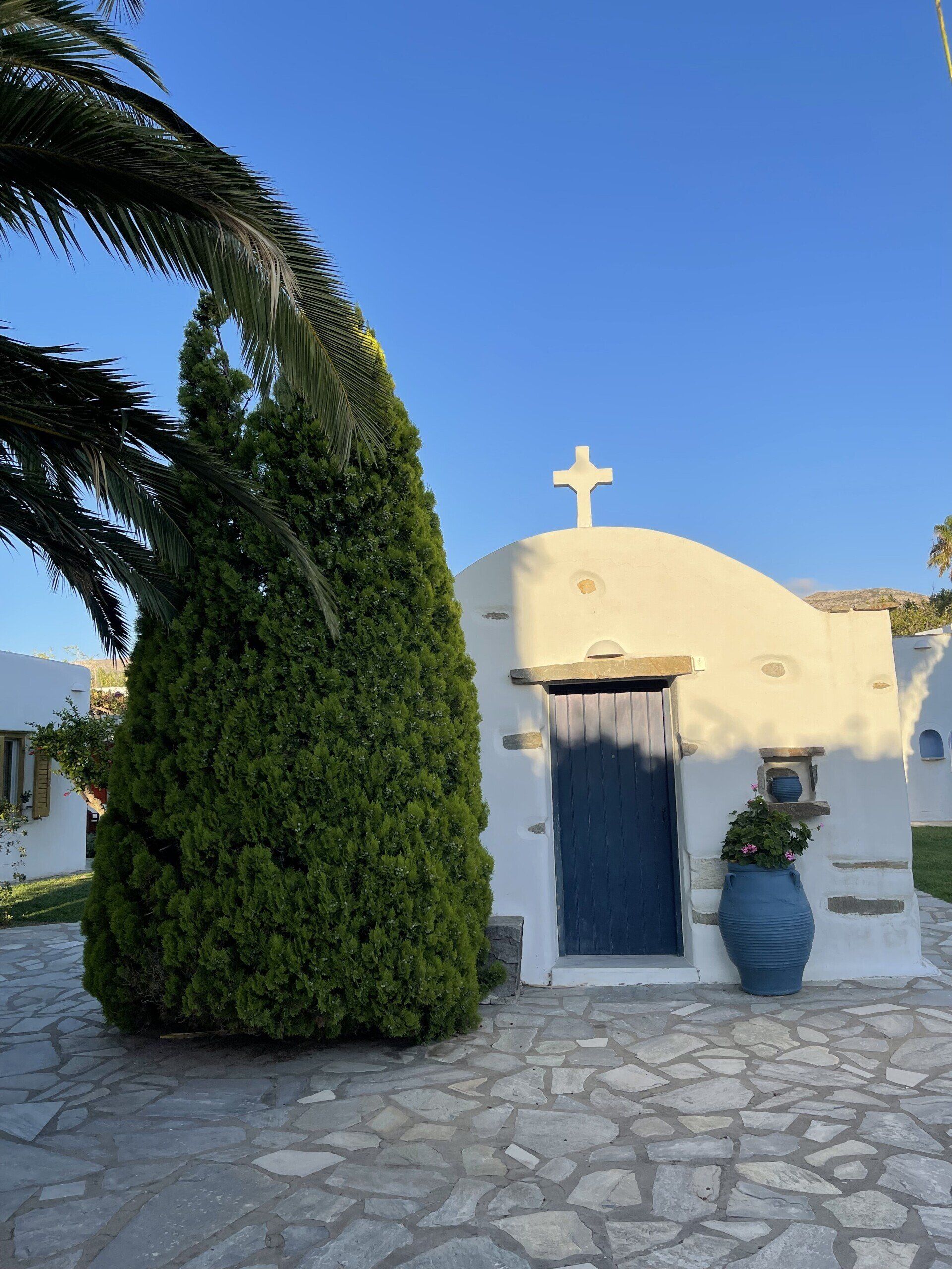A small white building with a cross on top of it