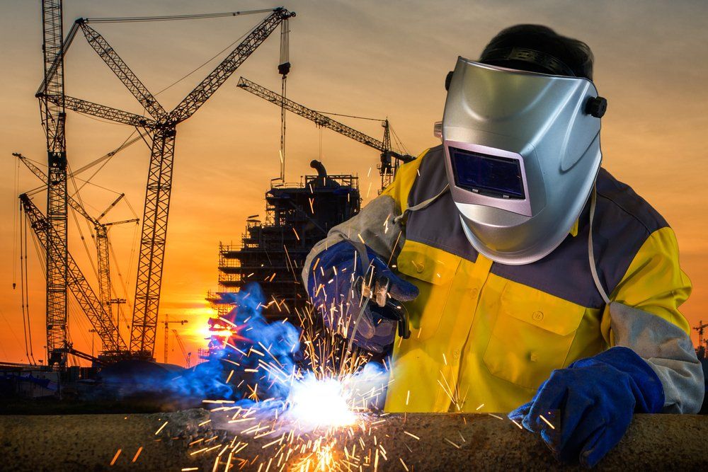 Welder Working a Welding Metal With Protective Mask — Cairns Electrical Rewinds & Repairs In Bungalow, QLD