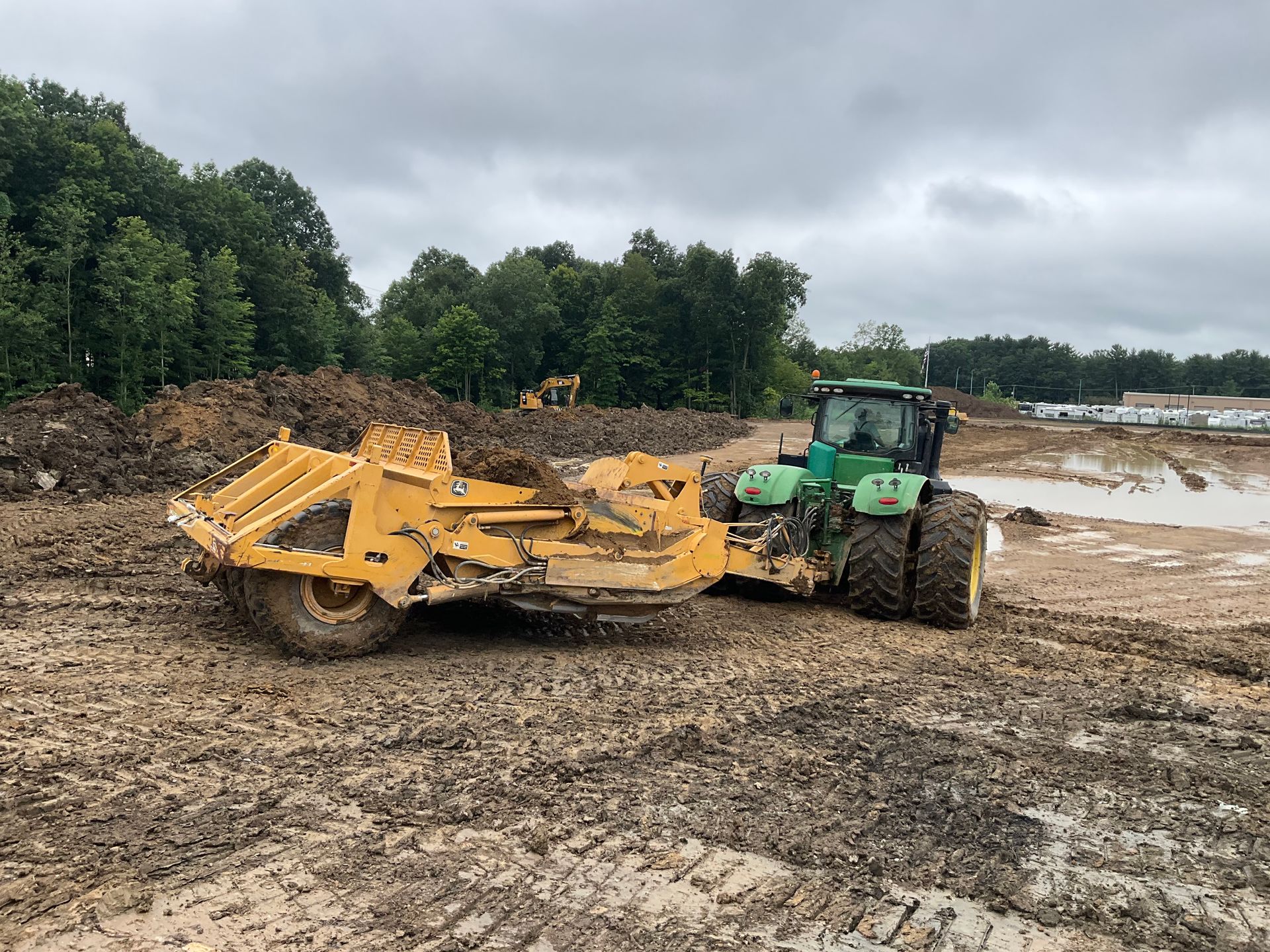 A man is working on a bulldozer on a dirt road.