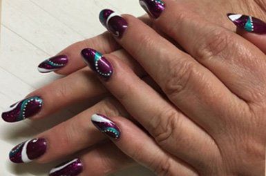 A close up of a person 's nails with a design on them.