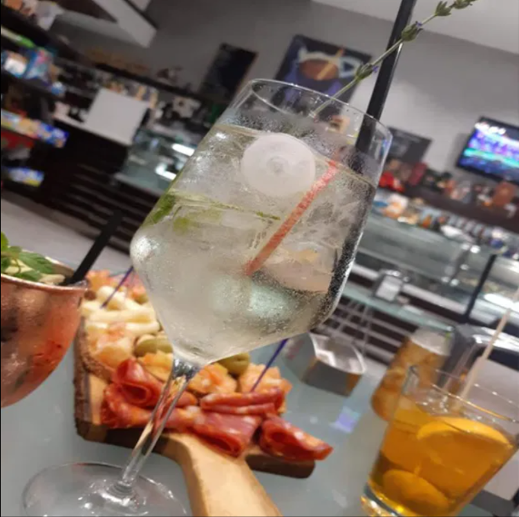 Un bicchiere da vino con ghiaccio e una cannuccia dentro