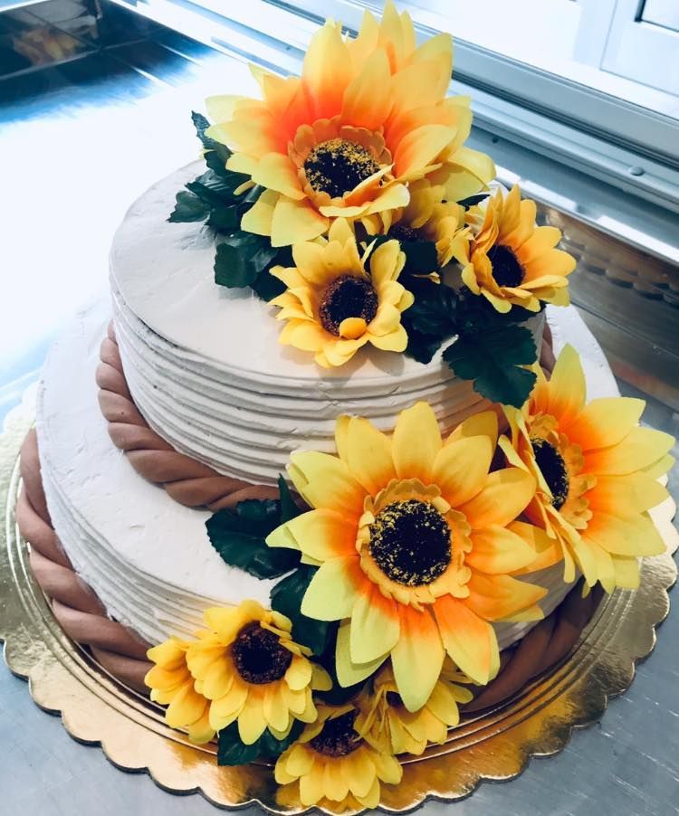 Una torta con sopra dei girasoli gialli e arancioni