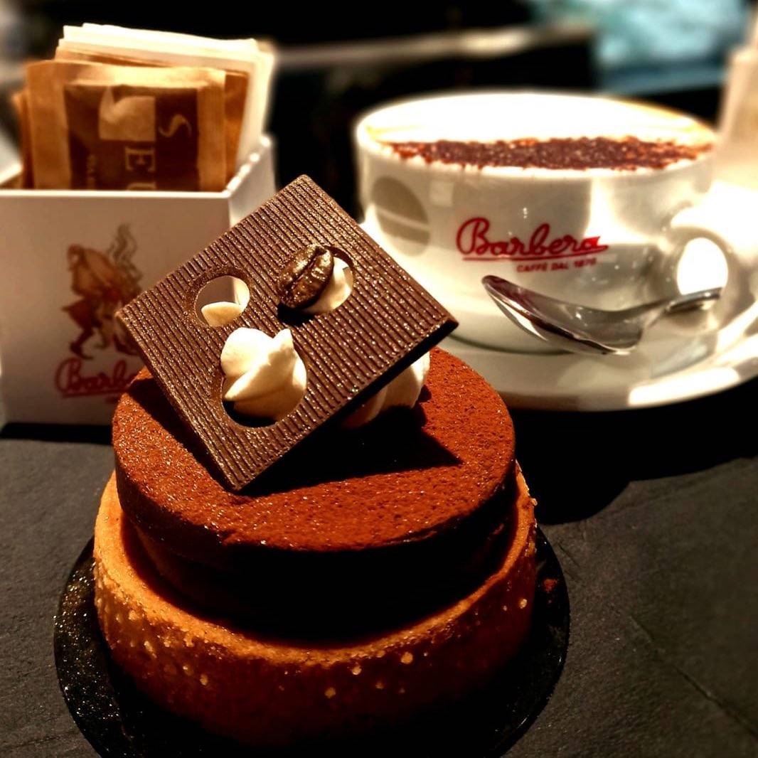 Una tazza di caffè Barbra è accanto a una torta