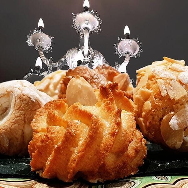 Biscotti sono appoggiati su un tavolo con delle candele sullo sfondo