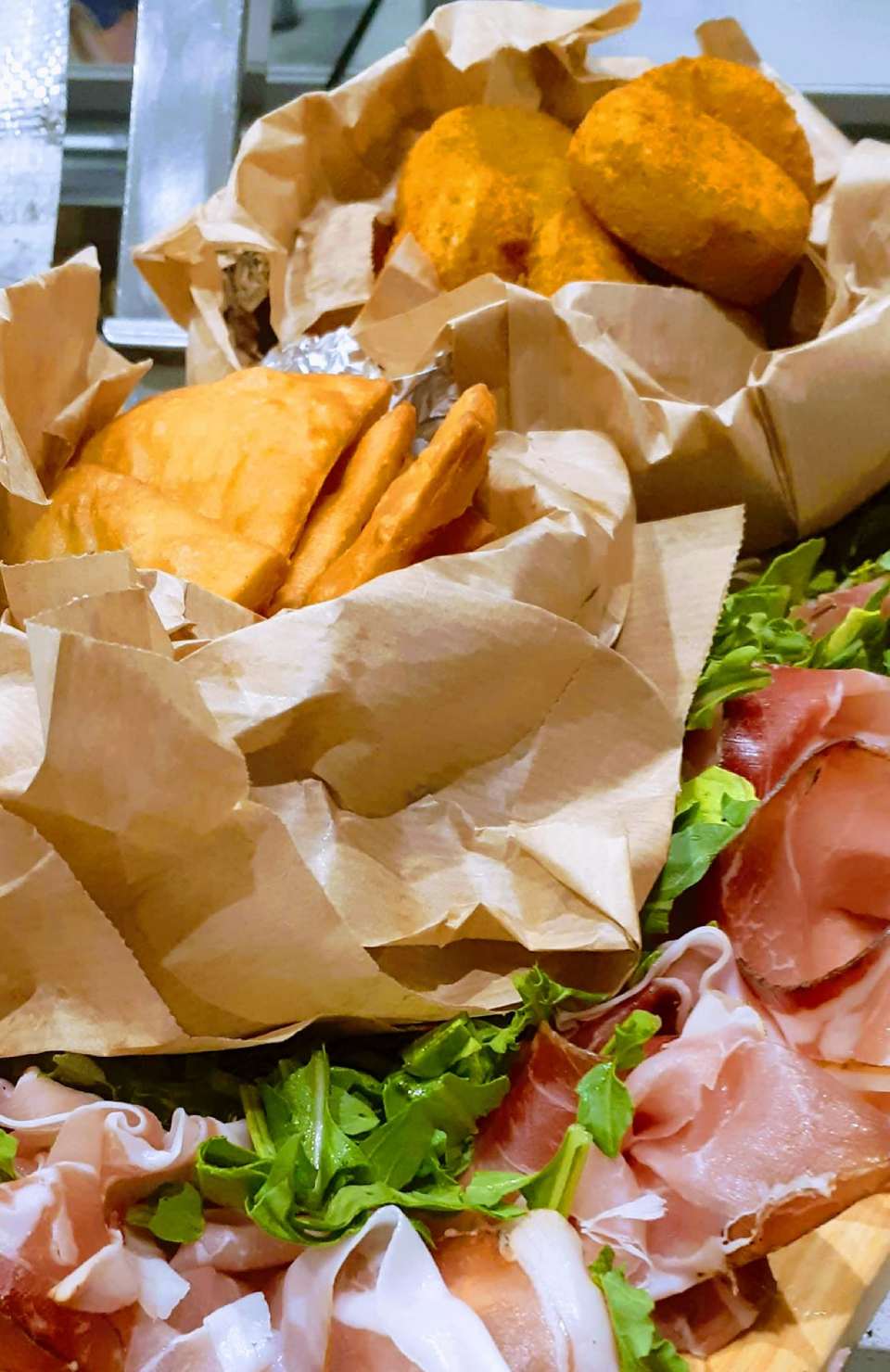 Primo piano di un vassoio di cibo avvolto in carta marrone su un tavolo.