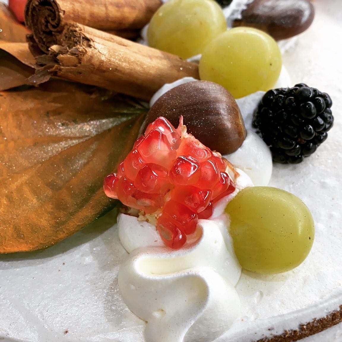 Un primo piano di una torta con panna montata e frutta sopra