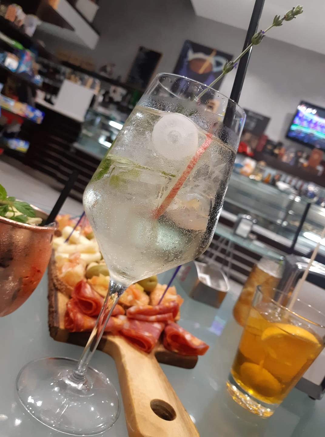 Un bicchiere di vino con ghiaccio e una cannuccia su un tavolo.